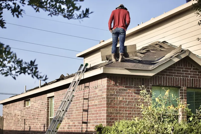 Professional roofer working on a residential roof in Enon